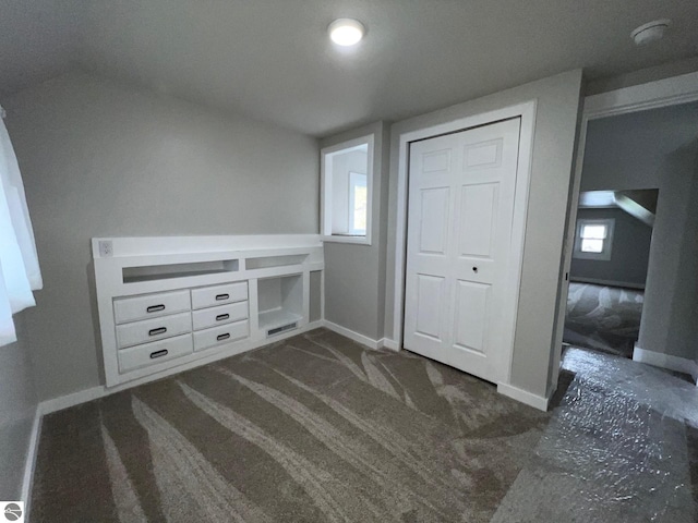 unfurnished bedroom with baseboards, multiple windows, and a closet