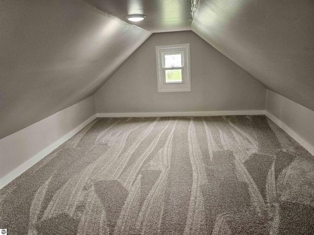 additional living space featuring baseboards, carpet flooring, and vaulted ceiling