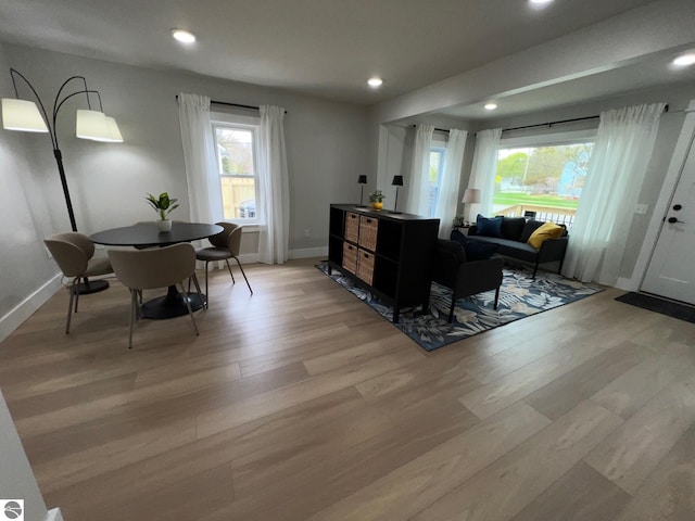 living area with light wood-type flooring, recessed lighting, and baseboards