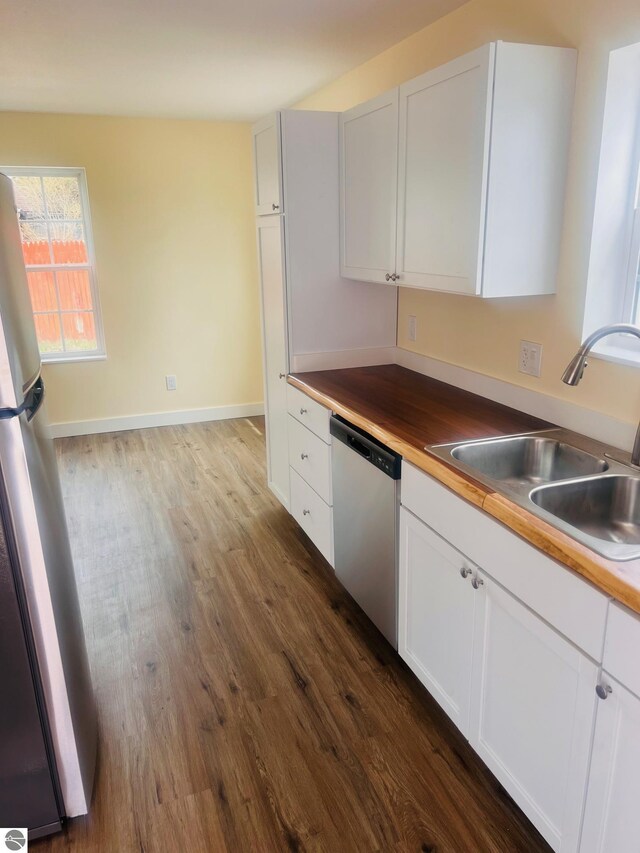 kitchen featuring a sink, white cabinets, stainless steel appliances, and dark wood finished floors
