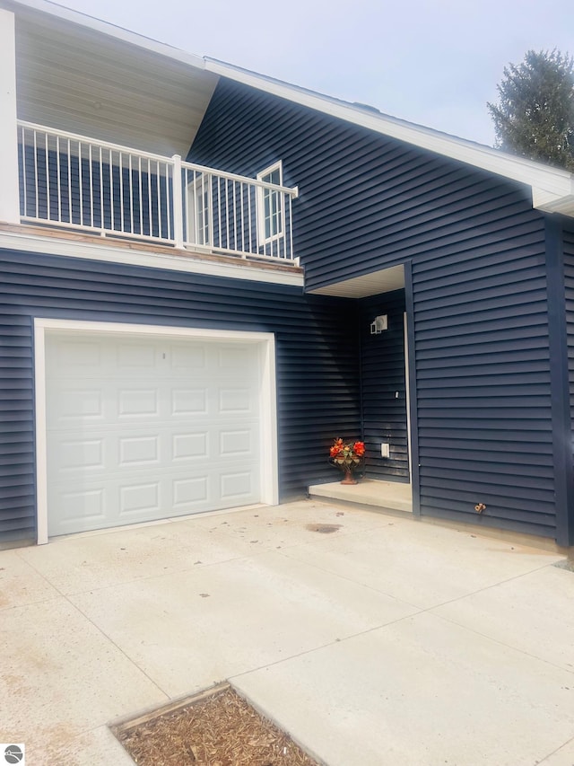 view of front of home with a garage, a balcony, and driveway