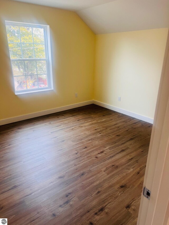 bonus room featuring baseboards, vaulted ceiling, and dark wood finished floors