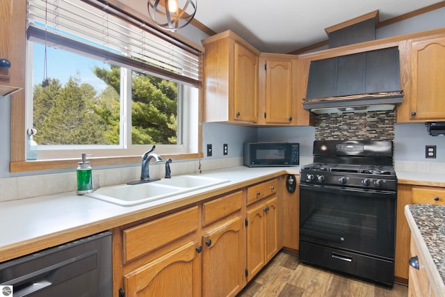 kitchen with a sink, ornamental molding, black appliances, and custom range hood