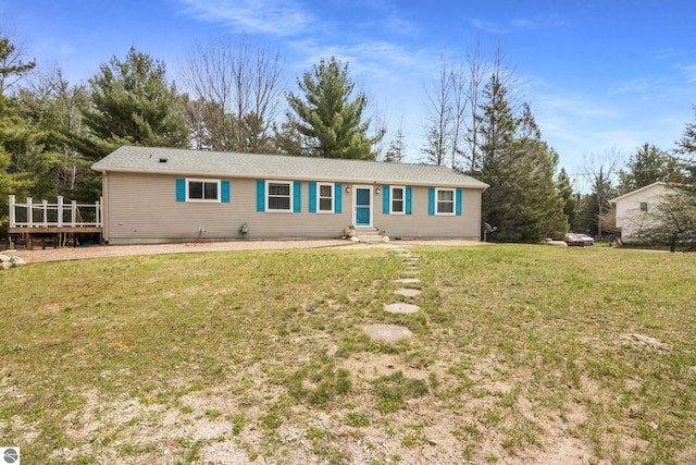 view of front of home featuring a wooden deck, entry steps, and a front lawn