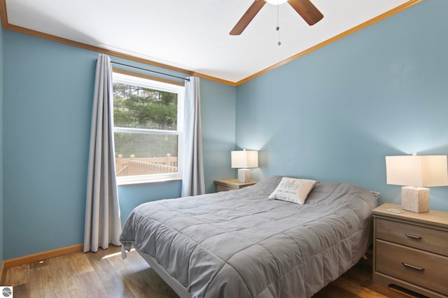 bedroom with baseboards, ornamental molding, a ceiling fan, and wood finished floors