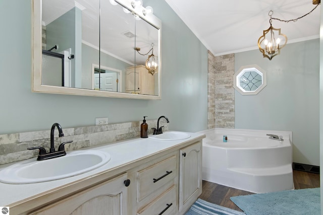 bathroom featuring a sink, crown molding, wood finished floors, and a notable chandelier