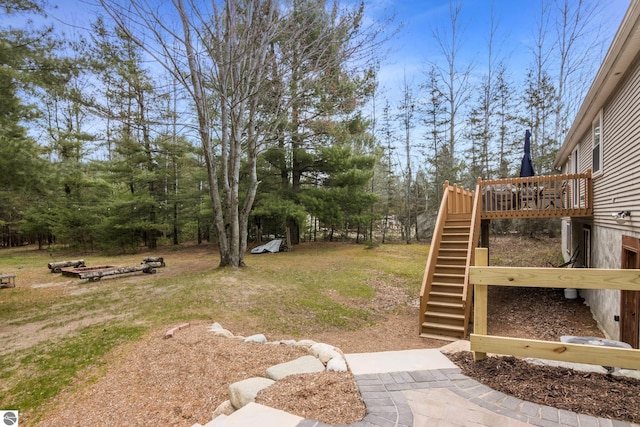 view of yard featuring a deck and stairway
