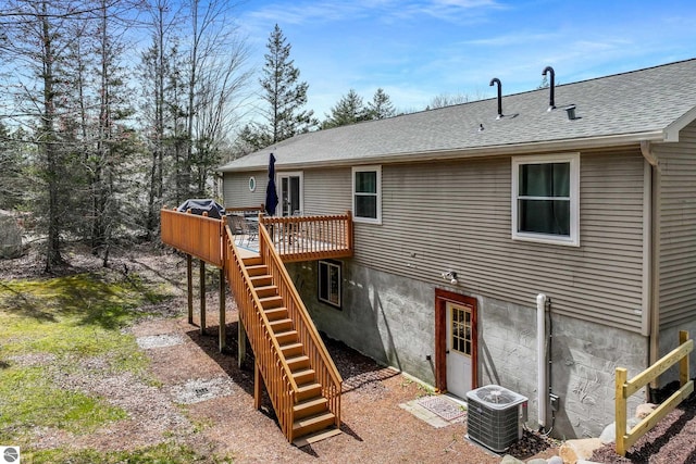rear view of house featuring a shingled roof, central AC unit, a deck, and stairway