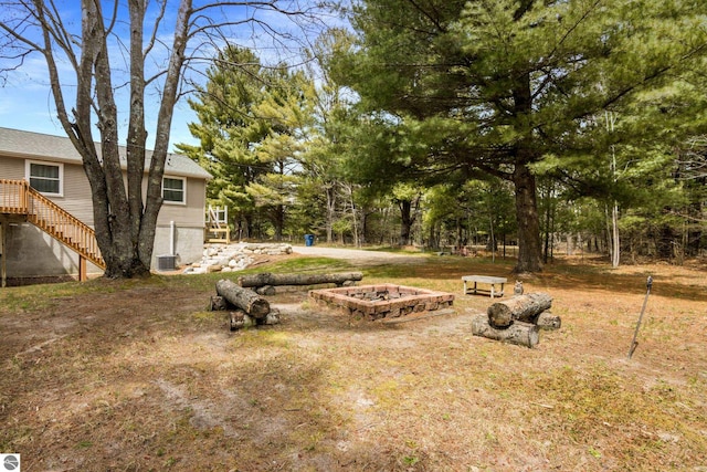 view of yard featuring a fire pit and stairway