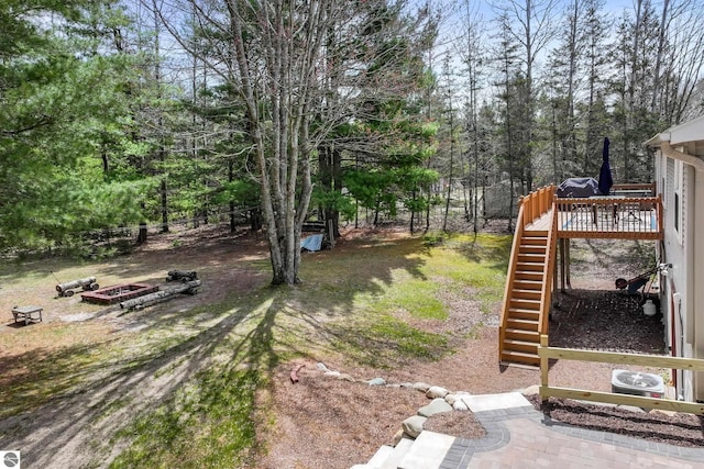 view of yard with a wooden deck and stairs