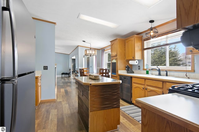 kitchen with a sink, a center island, freestanding refrigerator, black dishwasher, and wood finished floors