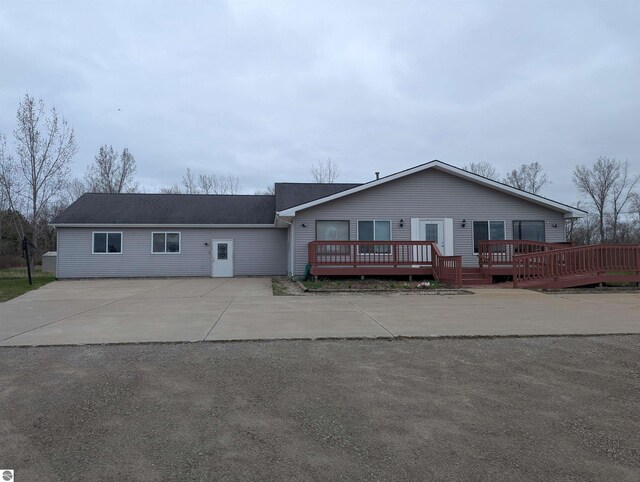 ranch-style house with driveway and a wooden deck