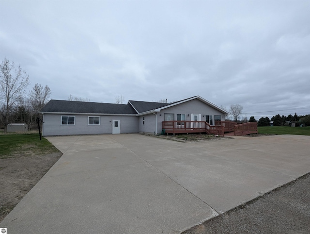 ranch-style home featuring driveway and a wooden deck