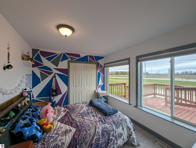 carpeted bedroom with baseboards and access to outside