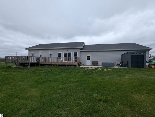 rear view of property with an outdoor structure, a wooden deck, a lawn, a hot tub, and a storage shed