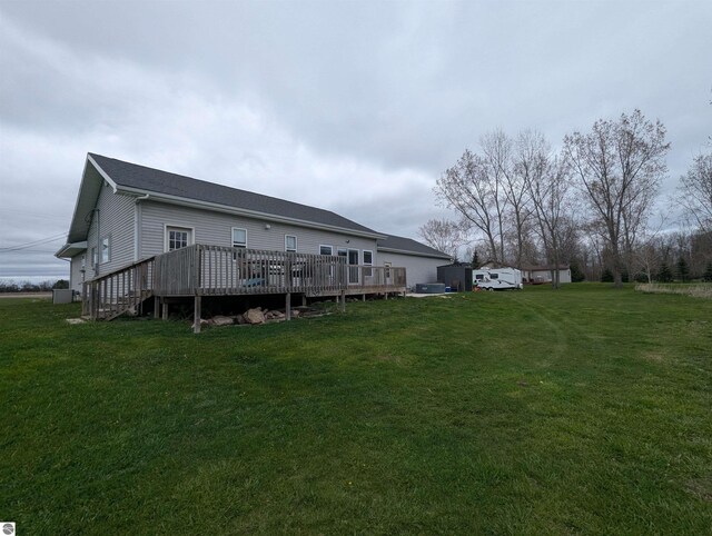 rear view of property with a lawn and a wooden deck