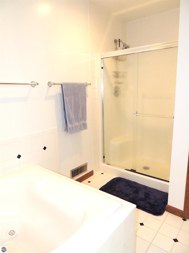 bathroom featuring visible vents, a garden tub, and a stall shower