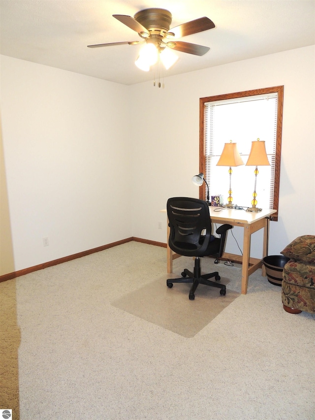 office space featuring carpet floors, a ceiling fan, and baseboards