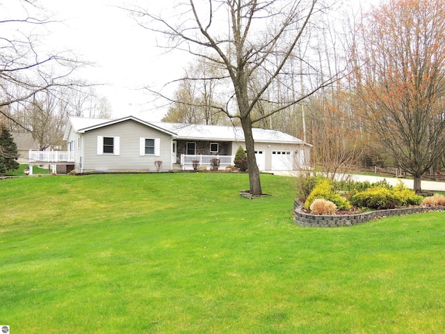 view of front of property featuring an attached garage, a porch, and a front yard