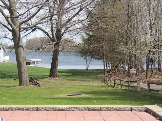 surrounding community featuring a lawn and a water view