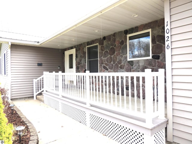 property entrance with covered porch and stone siding