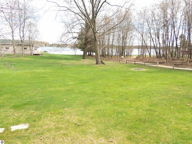 view of yard featuring a water view and fence