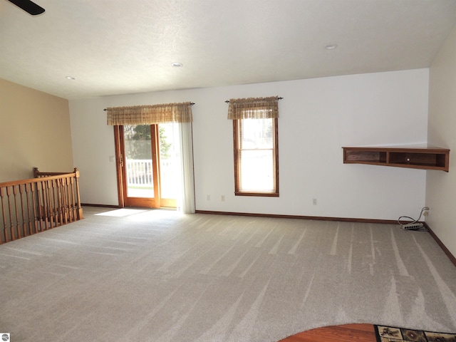 unfurnished living room with baseboards, carpet, and recessed lighting