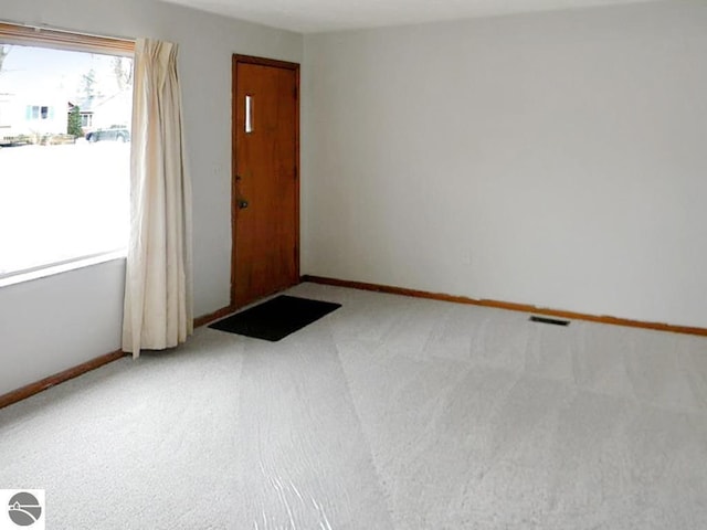 carpeted spare room featuring baseboards
