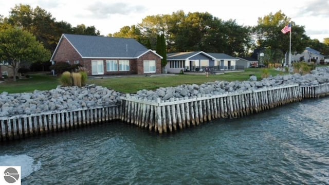 dock area featuring a lawn and a water view