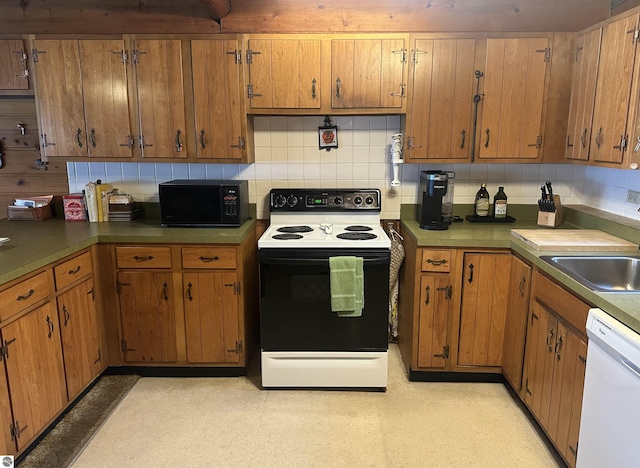 kitchen featuring white dishwasher, electric range, black microwave, a sink, and backsplash