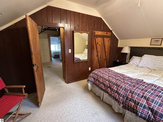 bedroom featuring wood walls, vaulted ceiling, and light carpet