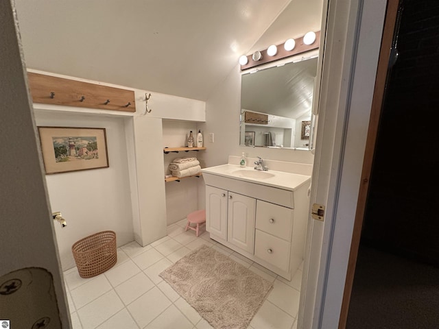 bathroom featuring tile patterned flooring, lofted ceiling, and vanity