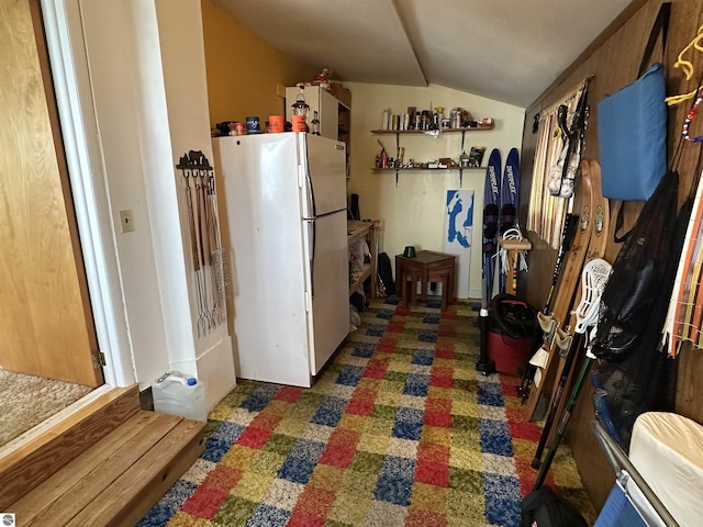 kitchen with freestanding refrigerator and lofted ceiling