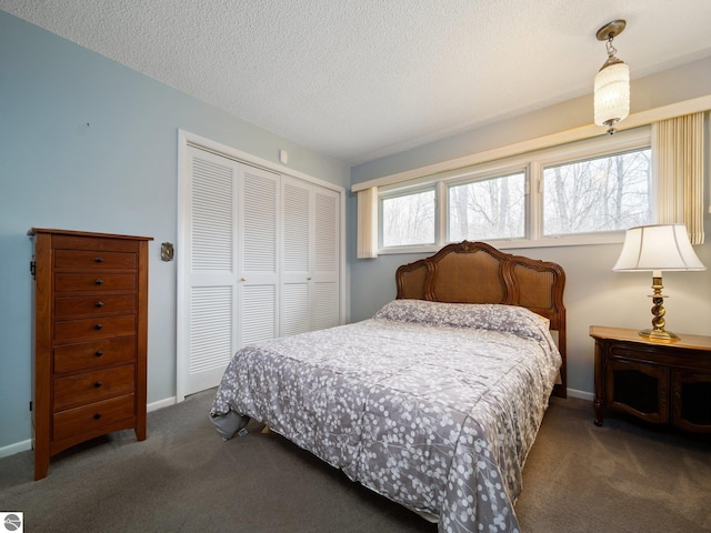 bedroom featuring carpet floors, baseboards, a closet, and a textured ceiling