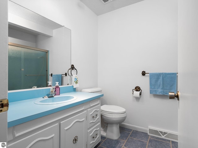 bathroom featuring visible vents, vanity, baseboards, toilet, and a shower with door