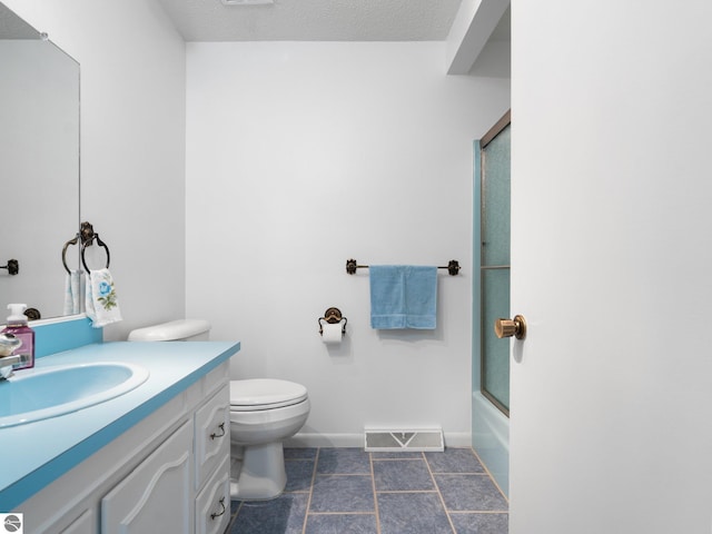 bathroom with visible vents, vanity, baseboards, bath / shower combo with glass door, and toilet