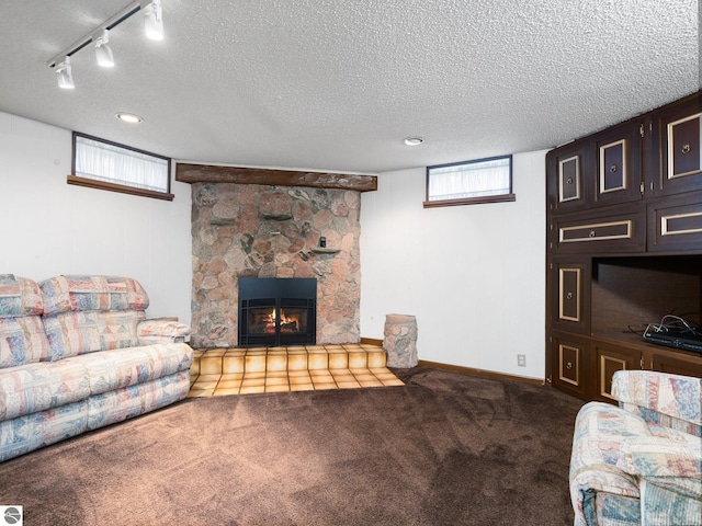 living area with track lighting, carpet flooring, a textured ceiling, and a fireplace