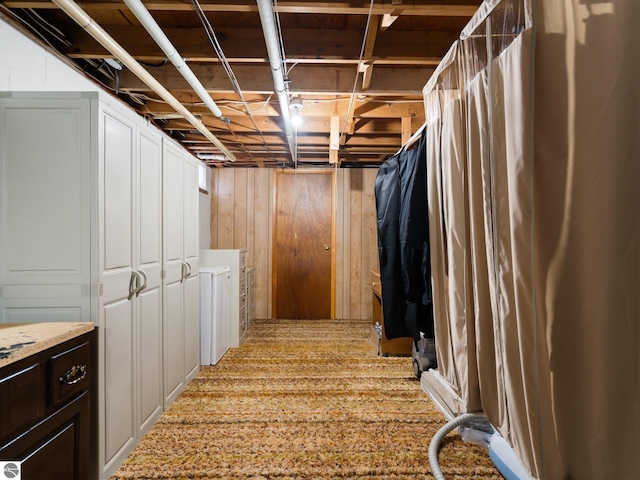 below grade area featuring wooden walls and washer / clothes dryer