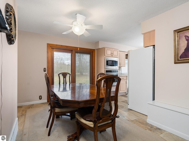 dining room with baseboards, a ceiling fan, a textured ceiling, and visible vents