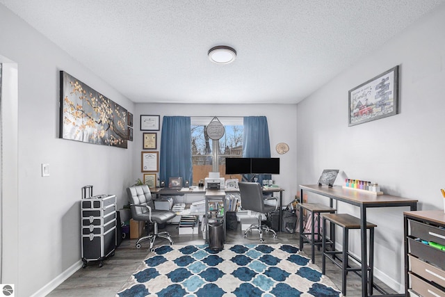 home office with baseboards, a textured ceiling, and wood finished floors