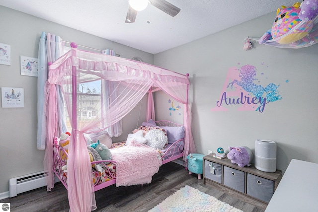 bedroom with a ceiling fan, a baseboard heating unit, and wood finished floors