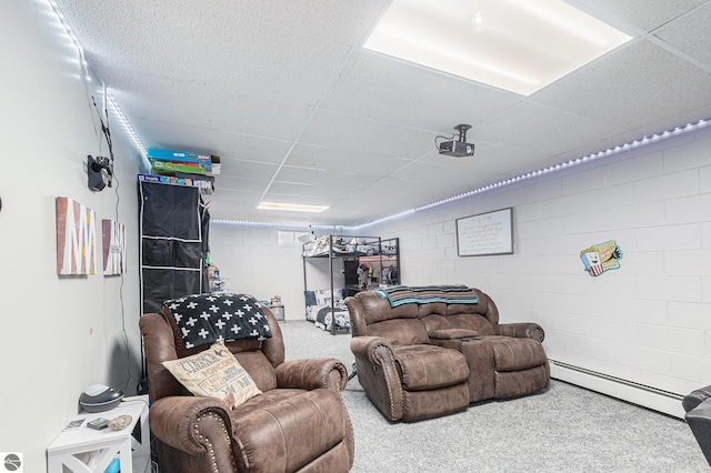 living area with carpet flooring, concrete block wall, a paneled ceiling, and a baseboard radiator