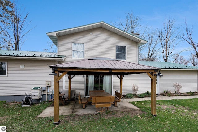 rear view of house featuring a gazebo, a patio area, a yard, and metal roof