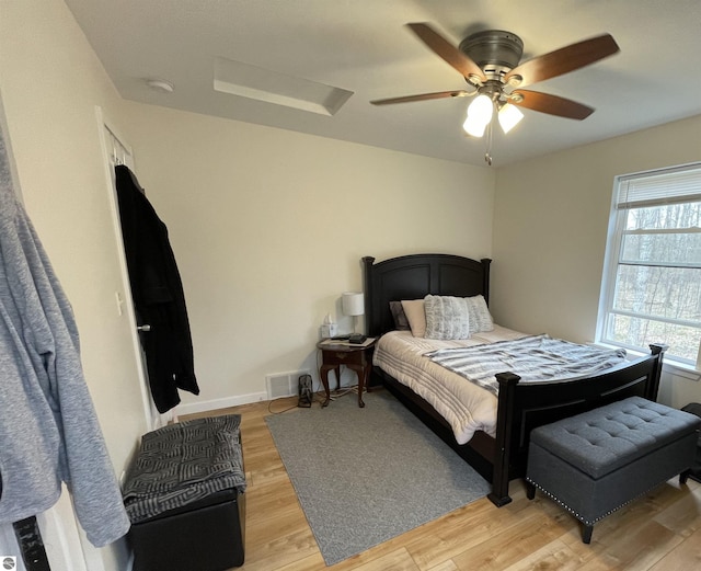 bedroom with ceiling fan, visible vents, and light wood-type flooring