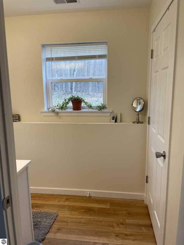 laundry room featuring light wood-style floors, baseboards, and visible vents