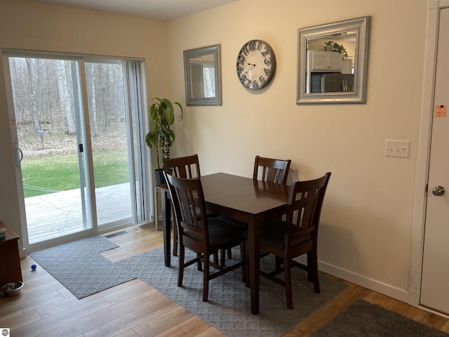 dining space with plenty of natural light, wood finished floors, and visible vents