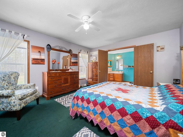 carpeted bedroom featuring multiple windows, ensuite bath, and ceiling fan