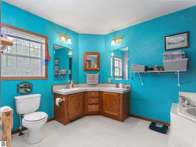 full bathroom featuring double vanity, toilet, baseboards, and a sink