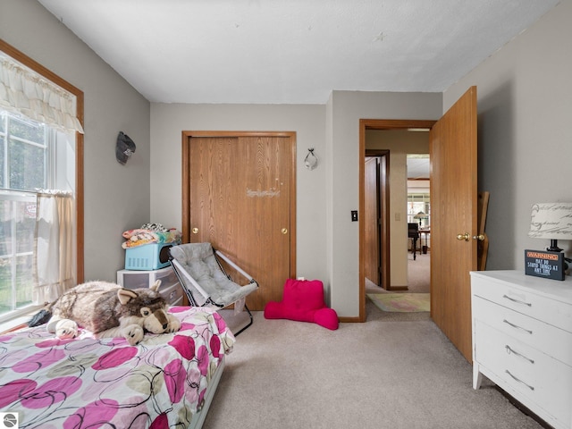 bedroom with light carpet and a closet