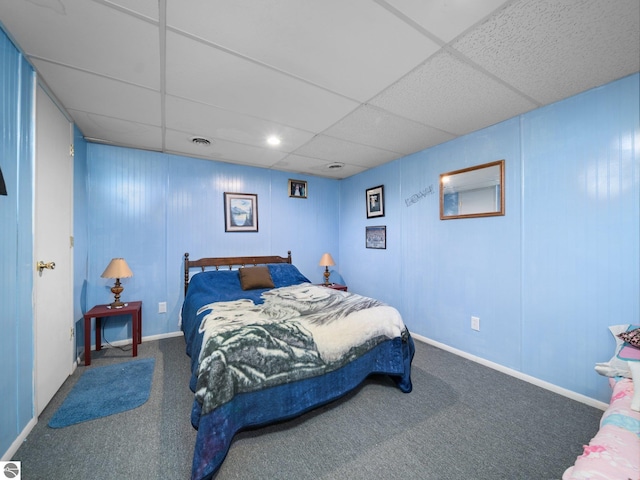 bedroom with carpet floors and a drop ceiling